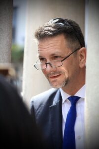 Steve Baker looking out from under High Wycombe Guildhall, wearing reading glasses with sunglasses on head